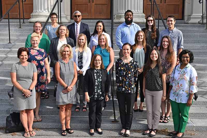 New professional staff pose on the steps of Sheldon Hall