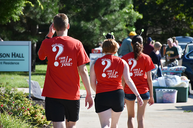 With T-shirts emphasizing their readiness to help, student volunteer Red Carpet Crew members head toward their next new community member moving into Johnson Hall