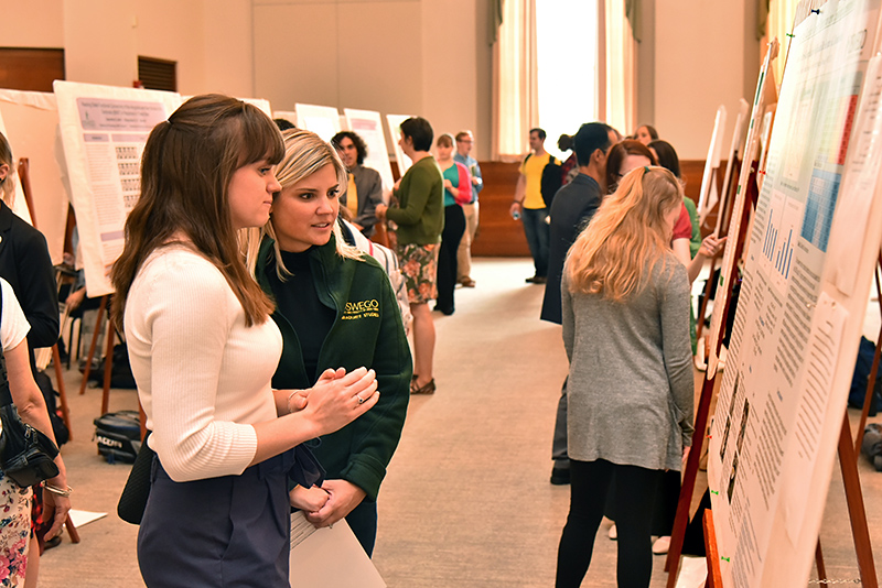 Charlotte Labrie-Cleary explains her chemistry research to Kristen Eichhorn