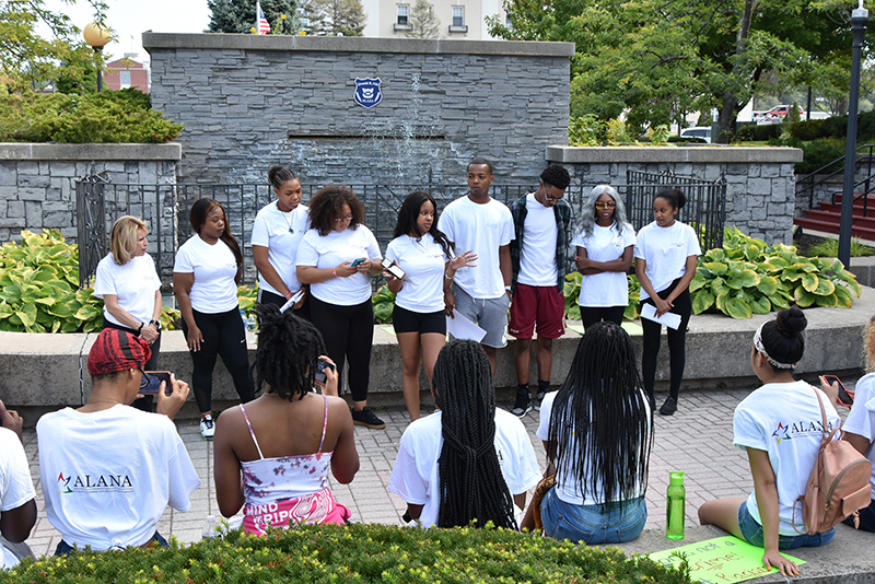 Imani Tate, a junior dual major in business and finance and Black Student Union president, speaks to participants downtown outside City Hall in advance of the annual ALANA Unity Peace Walk 