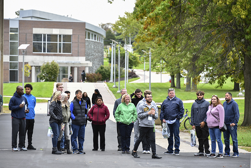 Nathan DeSantis, an adolescence education and Spanish major, leads a tour outside Penfield Library during the college's first Admissions Open House of the season