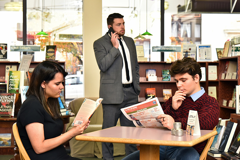 Production image in a bookstore for Dead Man's Cell Phone student honors theatre production