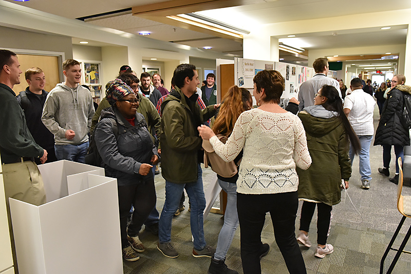 In a Nov. 9 event marking the 30th anniversary of the fall of the Berlin Wall, department of modern languages and literatures faculty member Ana Djukic-Cocks (foreground) ushers participants to symbolically walk from East to West through the dismantled wall