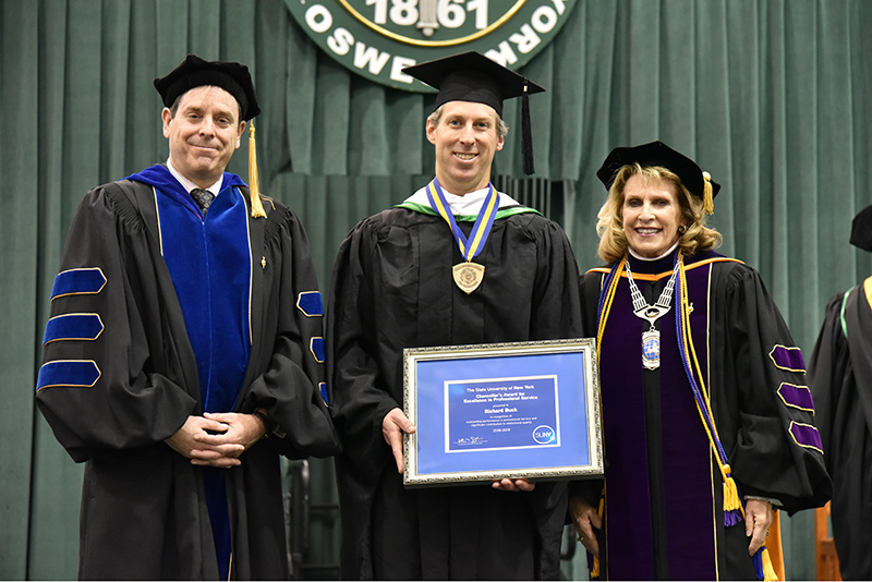  Richard Buck (center), director of digital services in the Office of Communications and Marketing, for receives a 2019 SUNY Chancellor’s Award for Excellence in Professional Service