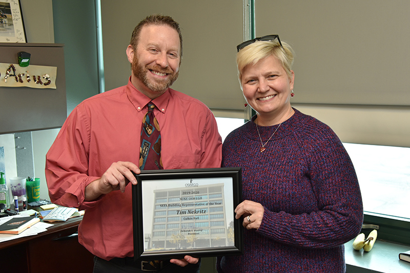 Tim Nekritz accepts the 2019-20 State Employee Federated Appeal Building Representative of the Year award presented by Mary Toale