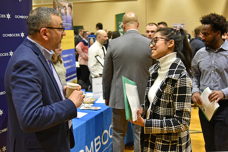 Ekta Siwakoti, a junior computer science and cognitive science dual major, talks during the March 4 Career and Internship Fair in Swetman Gymnasium with 1989 Oswego alumnus Phil Grome from OCM BOCES in Syracuse