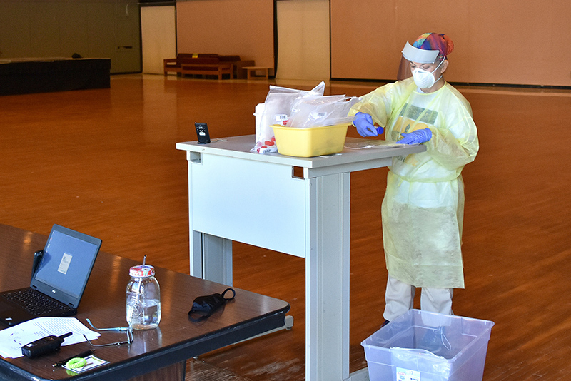 Tricia Vivlamore, a nurse practitioner with the college's Health Services, processes saliva swab samples Aug. 12 for COVID-19 in a procedure called "pooling" in Hewitt ballroom