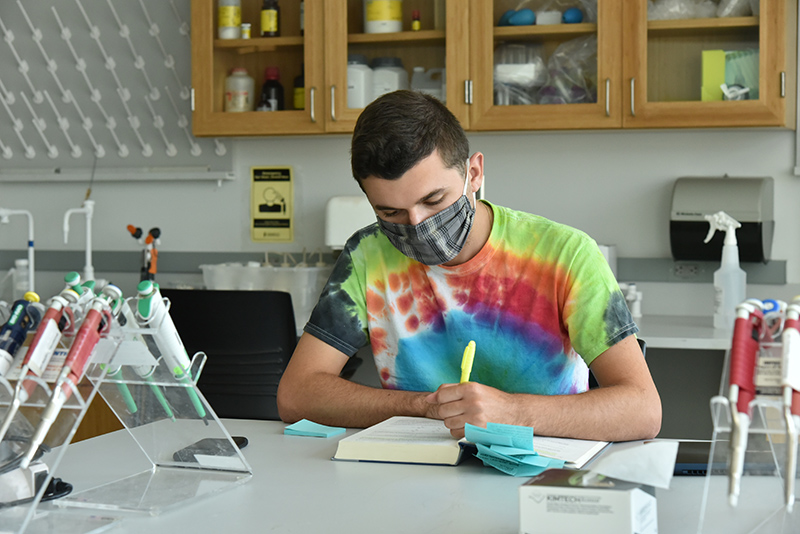 Anthony Pompa, a chemistry graduate student and teaching assistant for CHE113L, studies his textbooks during the first day of classes in the biochemistry teaching lab, 112 Shineman Center.