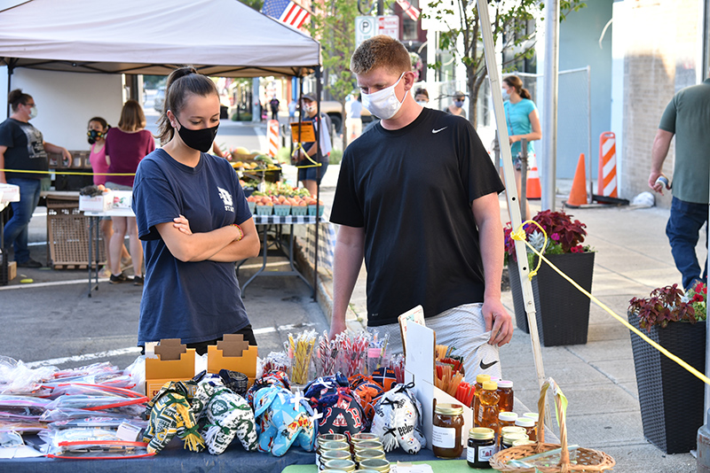 Audrey Meany, a December 2019 health education graduate, and John Kilkenny, an MBA/accounting graduate student, check out the Oswego Farmers’ Market along West First Street on Sept. 3, which was College Night at the popular Thursday event.