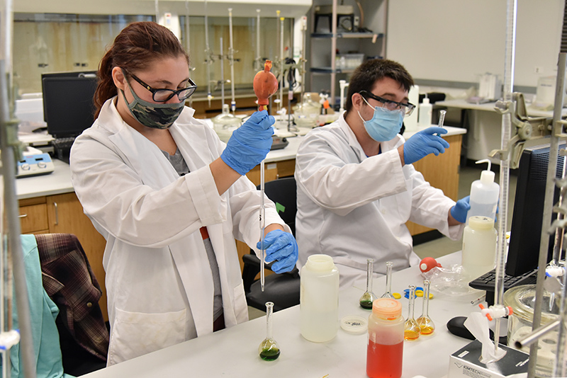 Working with instrumentation to analyze acidic ph levels with indicator solutions are Anna Makara, a senior chemistry major with concentration in environmental chemistry, and Michael Kirsch, a senior biochemistry major.