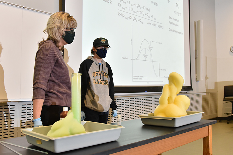 Timothy Moorhouse, a freshman chemistry major in Kristin Gublo's first-year seminar class (CHE 110F), demonstrates the creation of "Elephant Toothpaste." Once the catalyst is added to the simple ingredients, the volume greatly expands to overflow the container.