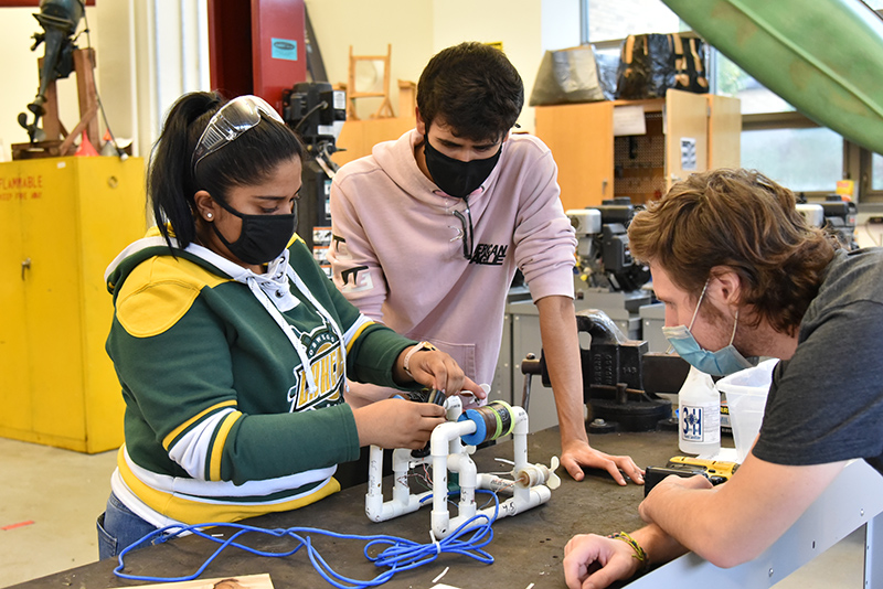 Working on a class assignment project that incorporates floating vehicle buoyancy, hydraulics, pumps and battery powered motors are (from left) junior technology education majors Shafia Ibrahim, Hunter Sabella and Ryan Parrish. Students work on a variety of technology assignments in the energy technology lab in the School of Education, 115 Park Hall, including these students in a course taught by Professor Richard Bush.