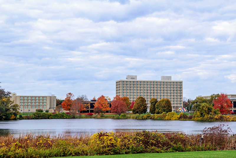 Colors on trees and an outdoor tent ring Glimmerglass Lagoon looking toward West Campus in this late October image. (Photo by Nsikak Ekong)