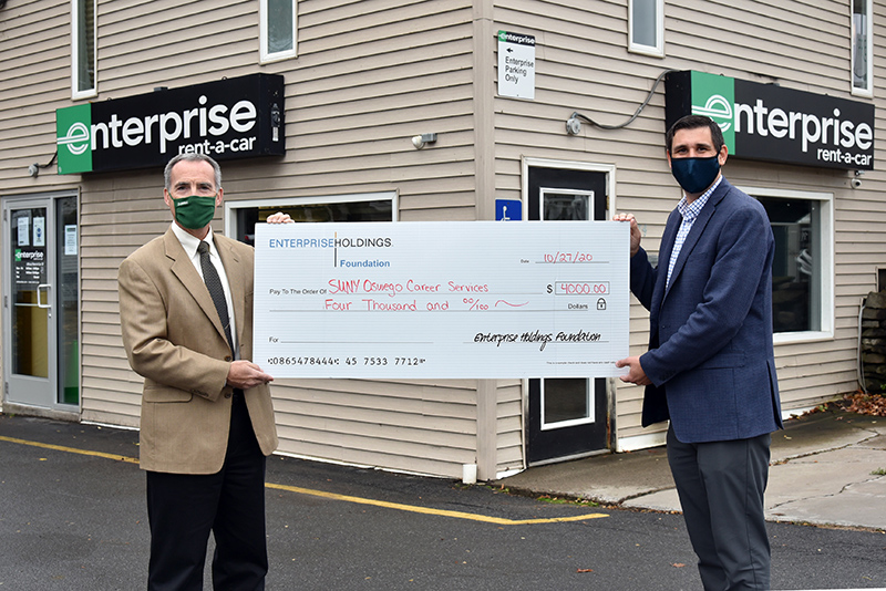 Enterprise Holdings Foundation presents a check for $4,000 to SUNY Oswego of Office Career Services. Presenting the check is Jody Giarrusso (right), talent acquisition specialist with Enterprise Human Resources. Accepting is Gary Morris (at left), director of SUNY Oswego Career Services.