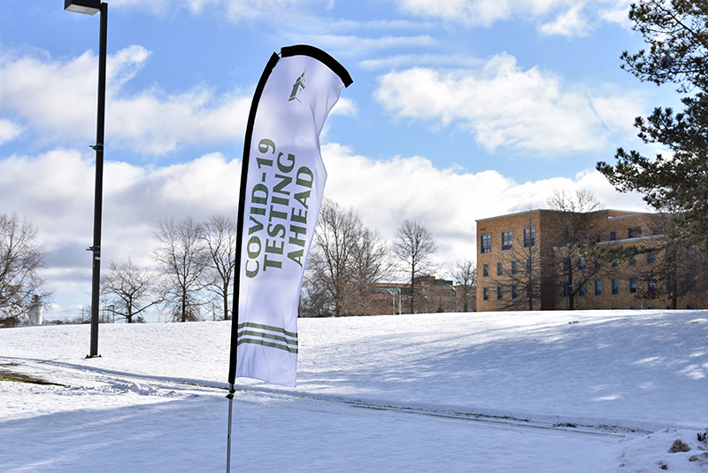 Flags placed along campus roads help navigate students arriving by car to the COVID testing area at Lee Hall. 