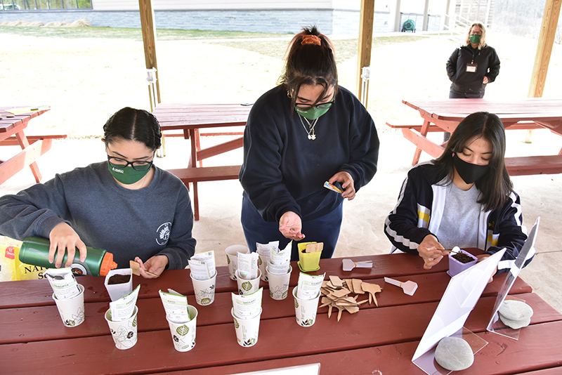 Pictured planting seeds of edible flowers and spices including chives, marigold and basil are sophomores, from left: Arianna Padilla, a psychology and wellness management dual major, Alexa Caban, a cinema and screen studies major, and Maria Salinas, a biological science major.