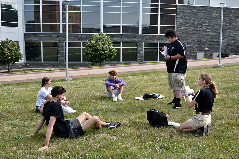 Laker Leaders Aziz Sarimsakov and Jordan Whitney speak to incoming students on the hill outside Marano Campus Center.