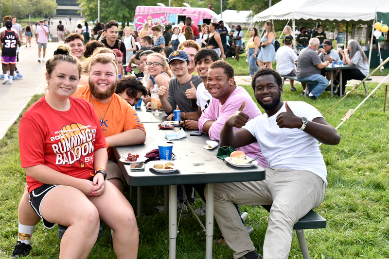 Yahya Ndiaye (right), a Laker Leader captain and double major in electrical and computer engineering and in French, gives a thumbs-up with friends at the Welcome Picnic Aug. 20.