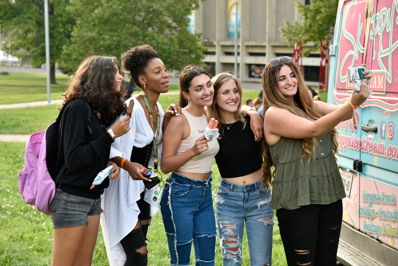Christina Nietzschmann pauses to take a photo of her and friends while enjoying the food and ice cream at the Welcome Picnic on Aug. 20.