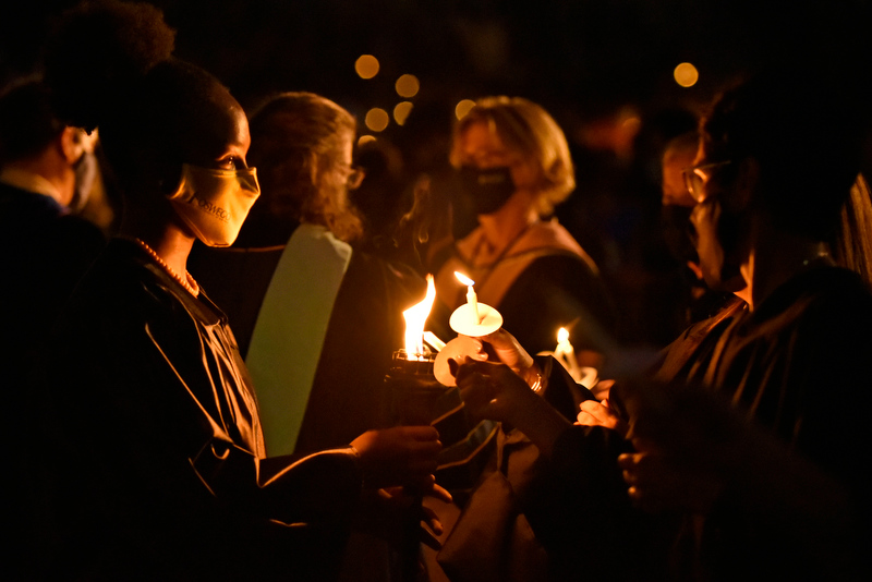 Senior Takayla Beckon, Student Association president and torchbearer, lights the candles of students and faculty at Welcoming Torchlight.