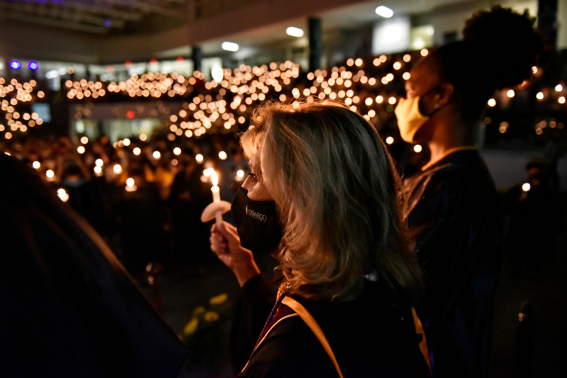 College President Deborah F. Stanley (left) and torchbearer Takayla Beckon, Student Association president, lift their candles at the conclusion of the 32nd annual Welcoming Torchlight Ceremony on Friday, Aug. 20. The ceremony is a traditional introduction to the academic year.