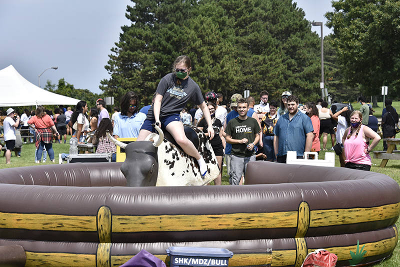 Niamh Walsh, a sophomore majoring in illustration, rides the mechanical rodeo bull during Lakerfest. Throngs of students came out Sept. 28 to enjoy the fun and food at the west campus residence halls location, which featured a variety of food, games, bounce houses, a high flying zipline and more. 