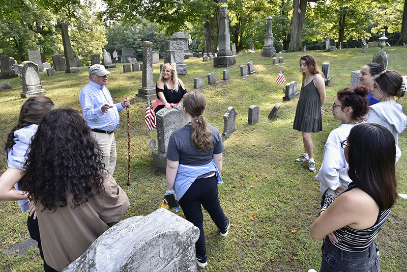 Theatre faculty member Jonel Langenfeld's storytelling class visited the Oswego Town Rural Cemetery where they will hold a live public performance featuring notable people of the past. On hand was Oswego Town Historian George DeMass, who also is a 1966 Oswego alumnus.