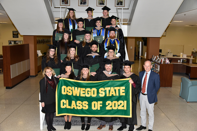 SRC Inc.employees earned their master of business administration (MBA) degree through a customized program with SUNY Oswego's School of Business. Pictured during a Dec. 11 Commencement reception are the graduates in a group photo with college President Deborah F. Stanley (left) and Joe Lauko of SRC, based in Syracuse.
