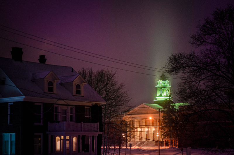 Sheldon Hall casts a colorful glow in the night sky during an Oswego snowfall Jan. 15.