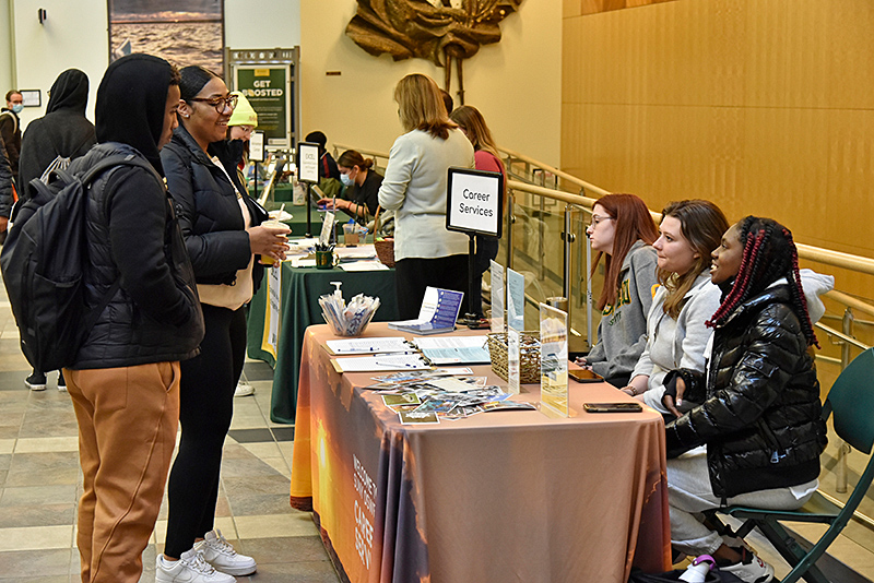 Staff from a wide variety of SUNY Oswego professional offices were on hand to talk with students about internship opportunities during the On-Campus Internship Expo on March 23 in the Marano Campus Center concourse. Pictured at the Career Services table is Imani Jones (foreground seated at right) with fellow Career Services Navigator interns talking with students. 