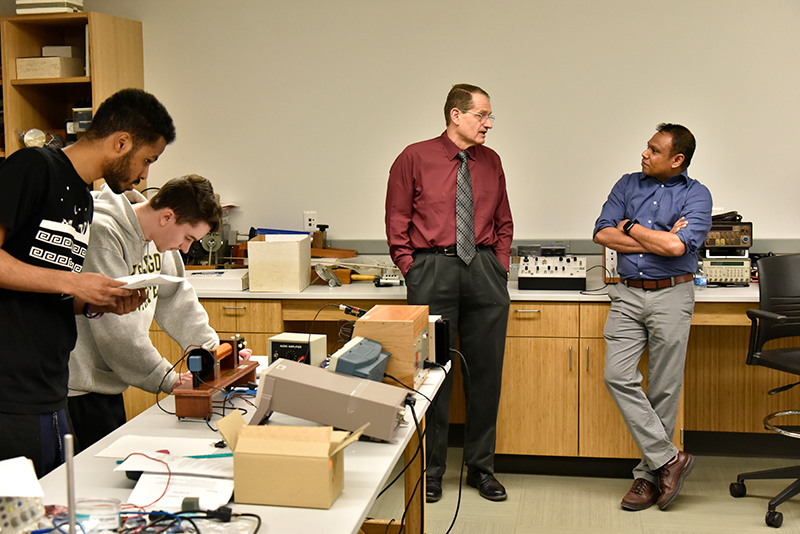 Paul Vianco (left), a 1980 alumnus and senior engineer with Sandia National Laboratories, speaks with faculty member Priyanka Rupashighe in the Shineman Center Optics Lab on March 23.
