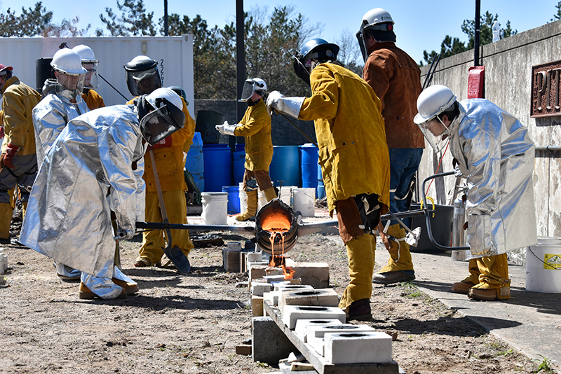 Art technology education students came together to host Oswego's annual Iron Pour on April 22 outside Tyler Hall. Raw iron is heated in an outdoor kiln to 3,000 degrees, then the liquified metal is poured into molds with designs carved by attendees. 