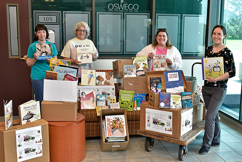 The Oswego Bookmobile collected donations of books through a campus-wide drive by the SUNY Oswego SEFA committee. Pictured at the pickup in Culkin Hall lobby are, from left: Bonnie Perfetti, Bookmobile Book Committee chairperson; Susan McBrearty, president of the Oswego Bookmobile; and SEFA Committee members Shelly Sloan from the Office of the Dean of Students and Kristen Haynes, assistant director of Rice Creek Field Station.