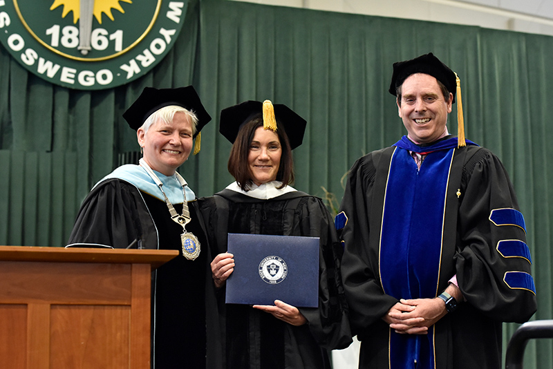 Susannah Melchior Schaefer, president and chief executive officer for Smile Train, received an honorary doctorate degree during the 4 p.m. School of Communication, Media and the Arts and School of Education Commencement ceremony. Schaefer, a class of 1990 alumna, also served as Commencement keynote for the ceremony. Officer in Charge Mary Toale and Scott Furlong, provost and vice president of academic affairs, bestow the honor.