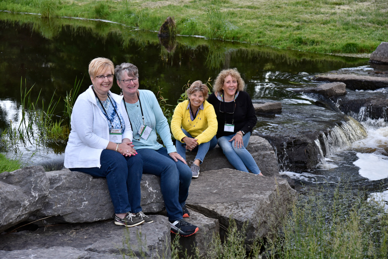 A group of friends enjoy the Rice Creek waterfall at Fallbrook while attending the Welcome Back Barbecue.