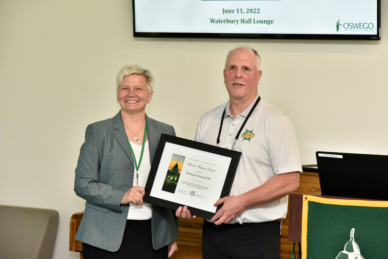 Michael Howard ’90, a nationally recognized head coach for Laker golf and wrestling and community athletics volunteer, receives the Alumni Impact Award during Reunion from Mary Toale, SUNY Oswego officer in charge.