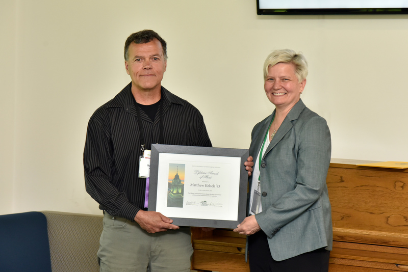 Matthew Kelsch ’83, an internationally recognized meteorologist and weather and environmental science educator, earned the Lifetime Award of Merit during the Oswego Alumni Association Award presentations during Reunion. Presenting is Mary Toale, SUNY Oswego officer in charge. 