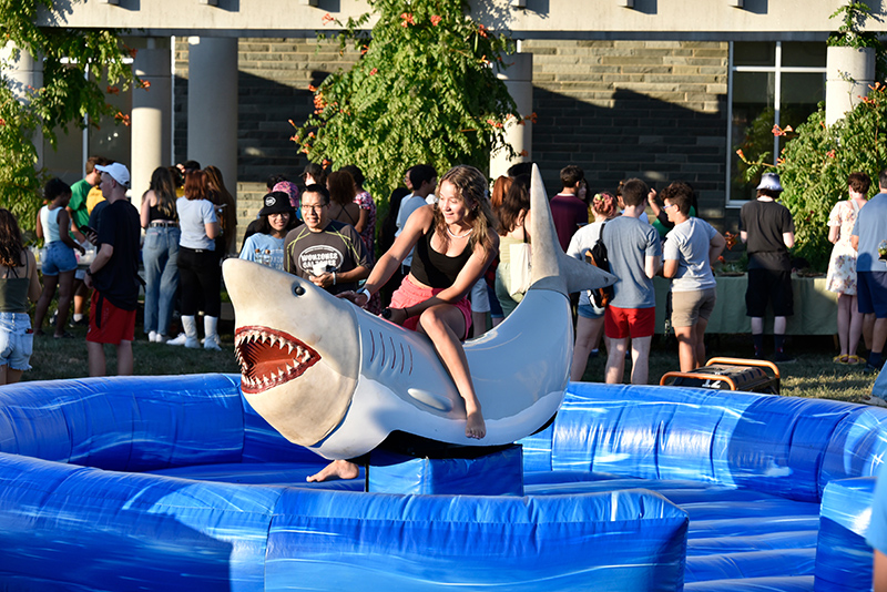 Student rides mechanical shark at Opening Picnic and Carnival on August 19, 2022 on SUNY Oswego campus.