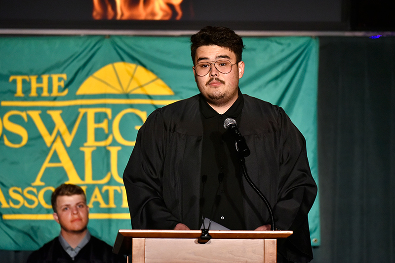 Student speaker Aziz Sarimsakov ‘24 at SUNY Oswego's Torchlight Ceremony addressing the audience