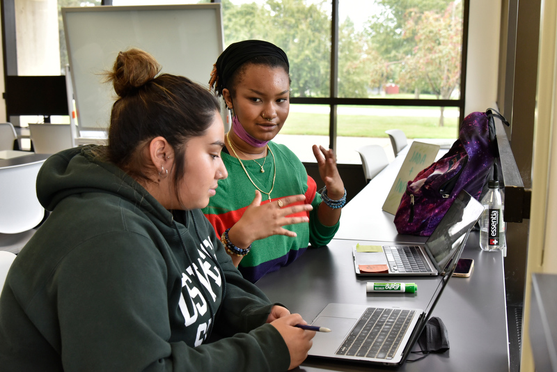 The Office of Learning Support Tutoring Center in Penfield Library offers one-to-one and small group help in class work in a variety of subjects. Chada LaRocca (pictured in foreground) gets help Sept. 21 with her Sociology 101 class from fellow Oswego student and tutor Infiniti Robinson.