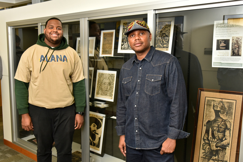 Newton Paul (right) – a 1997 alumnus, art collector and curator of his family's Cuban art collection, pictured with Latino Student Union president Matthews Frank – brought some of his Cuban artwork to campus.