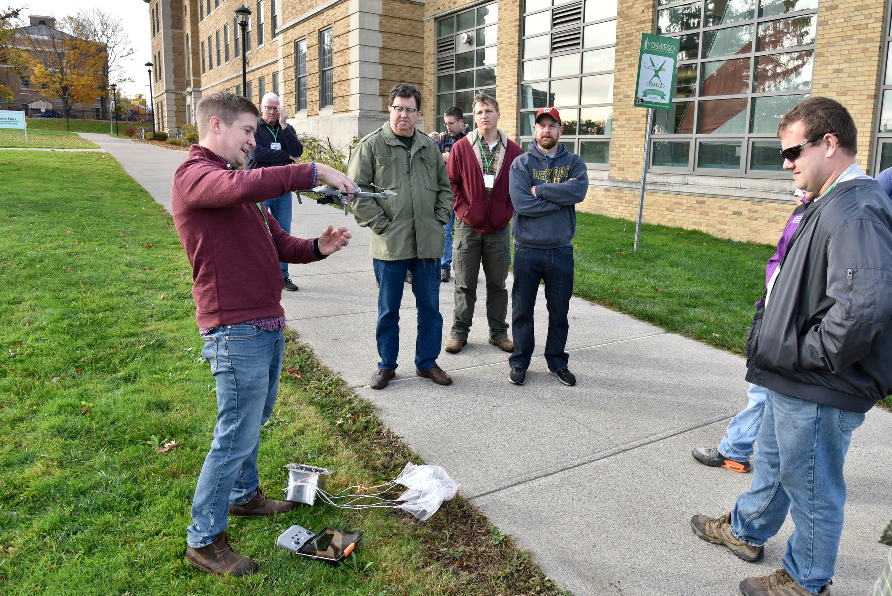 Technology education alumni presenter Leif Sorgule (pictured at left) explains the new technologies in "package delivery by drone" through hands-on demonstrations outside Park Hall during the 83rd annual Fall Technology Conference Oct. 28. He also explained how students can use applied math skills to construct containers and parachutes to be deployed safely by drone. 