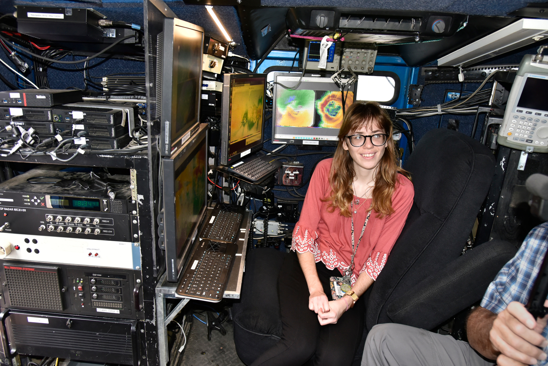 Samantha Karlsson, a senior meteorology major, sits at the array of meteorological instrumentation in the Doppler on Wheels (DOW) displayed during SUNY Oswego meteorology open house Nov. 5 outside the Shineman Center. 