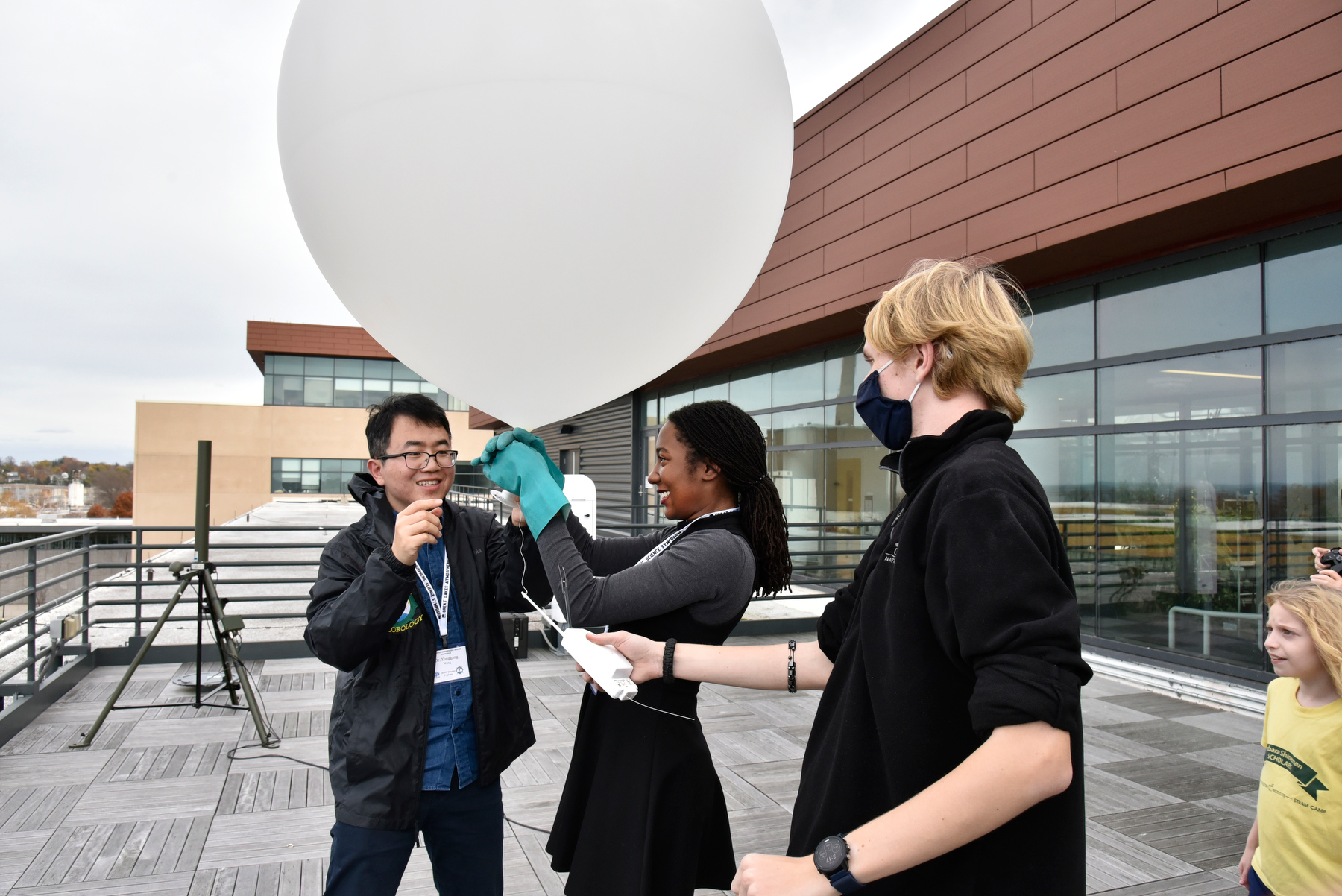 Meteorology faculty member Yonggang Wang (left), with students Josephine Ragland and Benjamin Lamsma, prepare to launch a weather balloon with instruments from the Shineman Center Observation Deck during the meteorology open house held Nov. 5. 