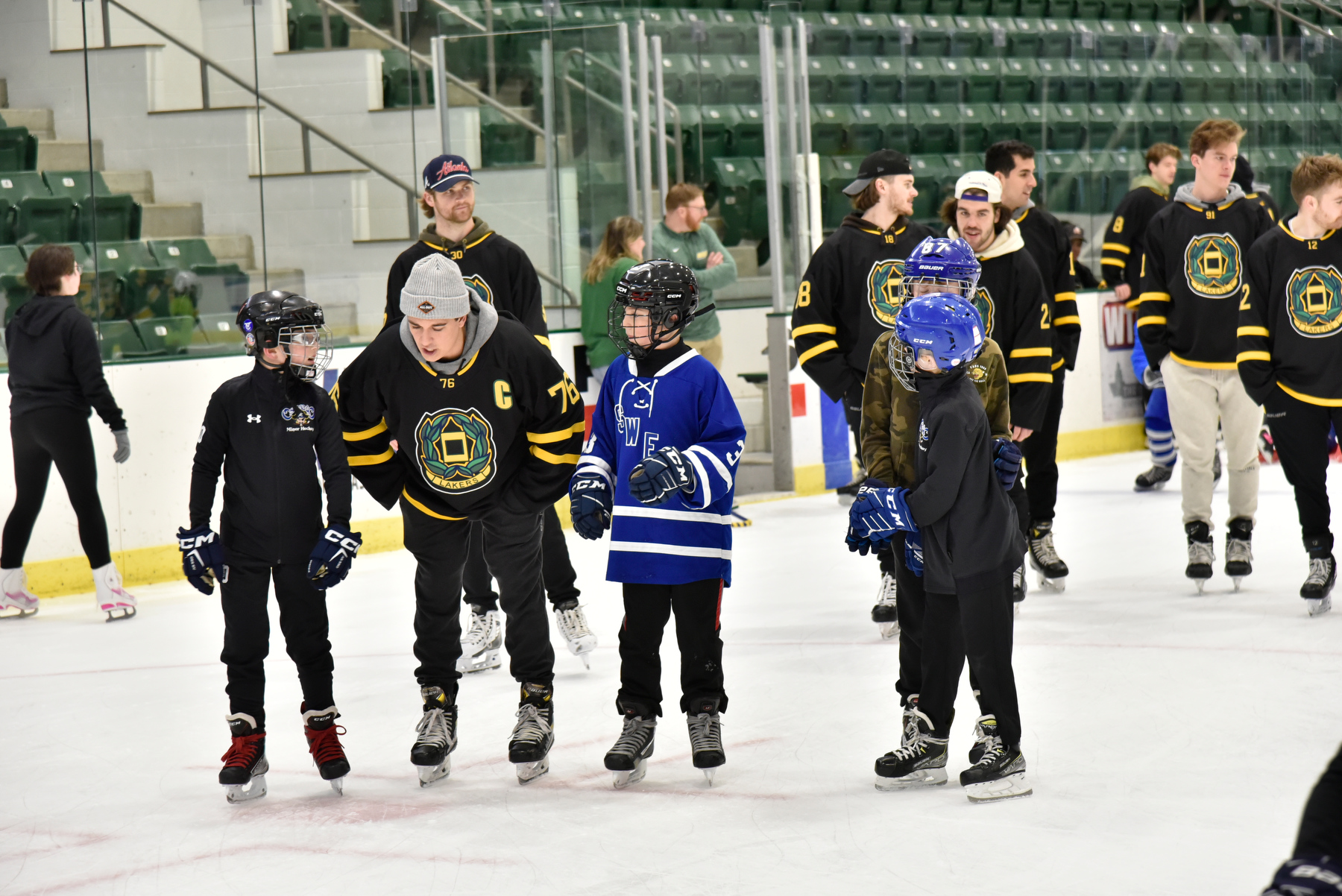Laker men's ice hockey team member Ryan Bunka (#76) talks with some young hockey players Dec. 4 during the Holiday Skate with the Lakers in the Marano Campus Center's Deborah F. Stanley Arena and Convocation Hall.