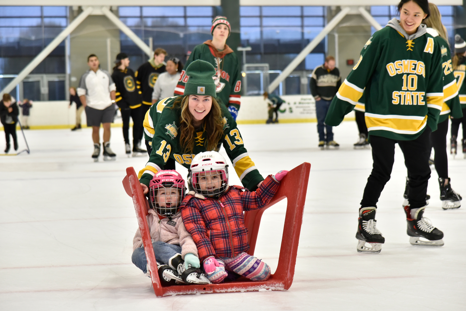 Laker women's hockey team member Ashlyn McGrath (#13) provides some fun around the rink for some young fans during the popular annual Holiday Skate with the Lakers held Dec. 4 in the Marano Campus Center's Deborah F. Stanley Arena and Convocation Hall.