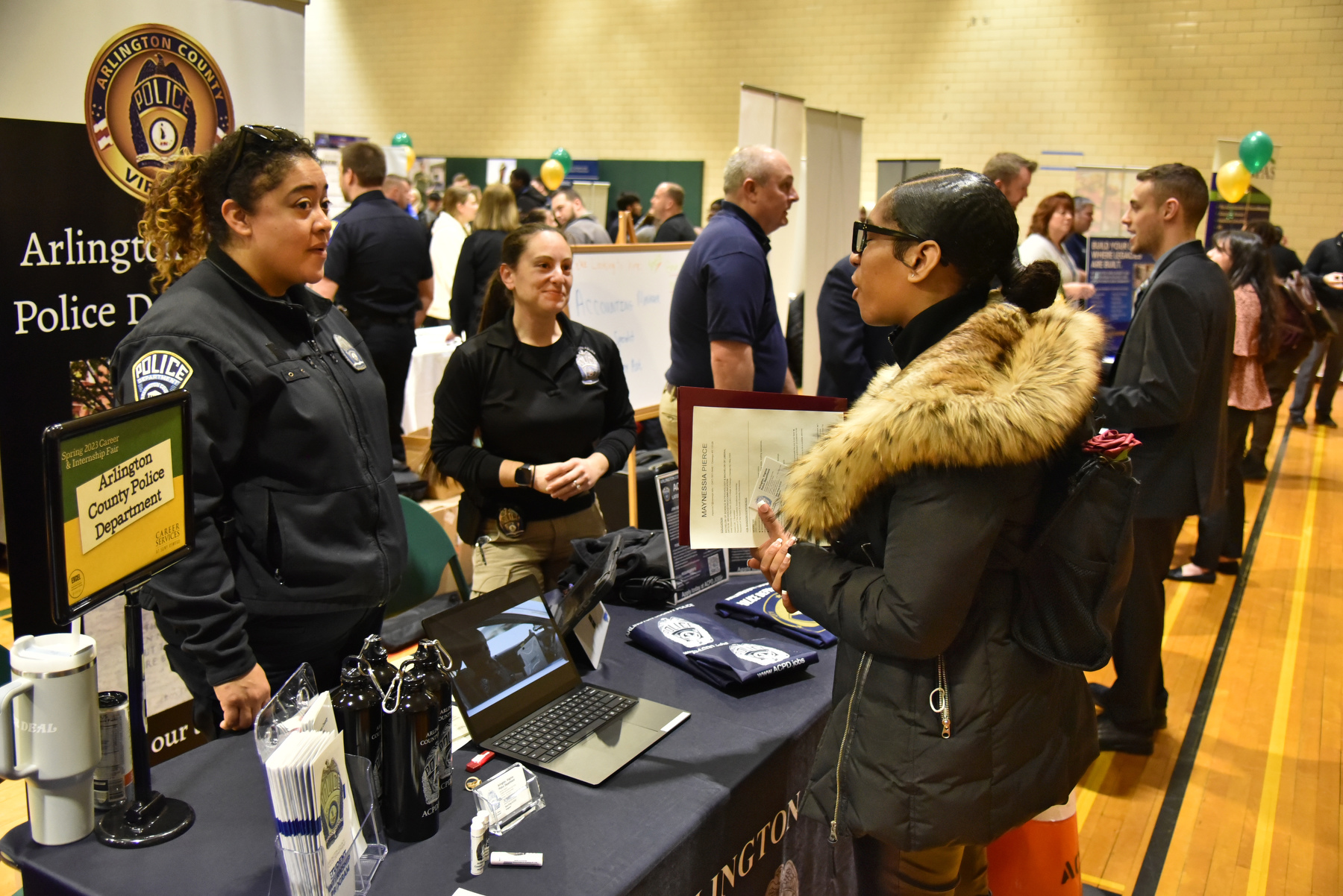 During the March Spring Career and Internship Fair, Maynessia Pierce (pictured at right), a junior psychology and broadcasting dual major, talks with Arlington County Police Officers attending the fair.