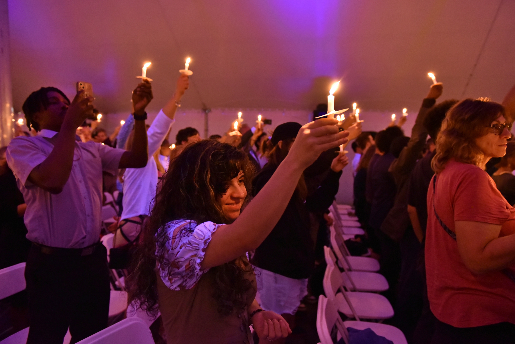 Graduating seniors, families and guests hold up their candles to celebrate the passing of knowledge during the Torchlight Ceremony.