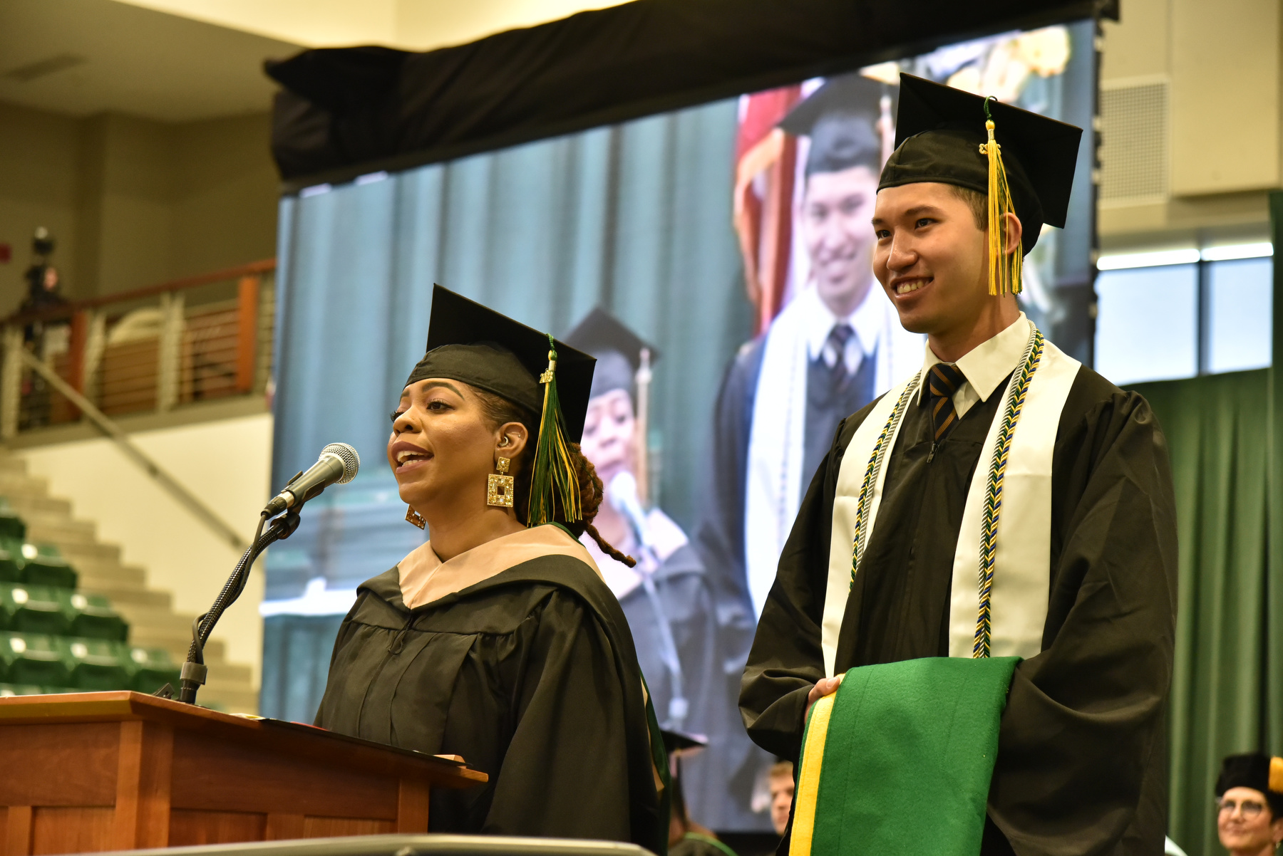 Graduates Valery Stewart and Dee Sheng "Eason" Lee presented the alumni banner at the ceremony for the School of Business.