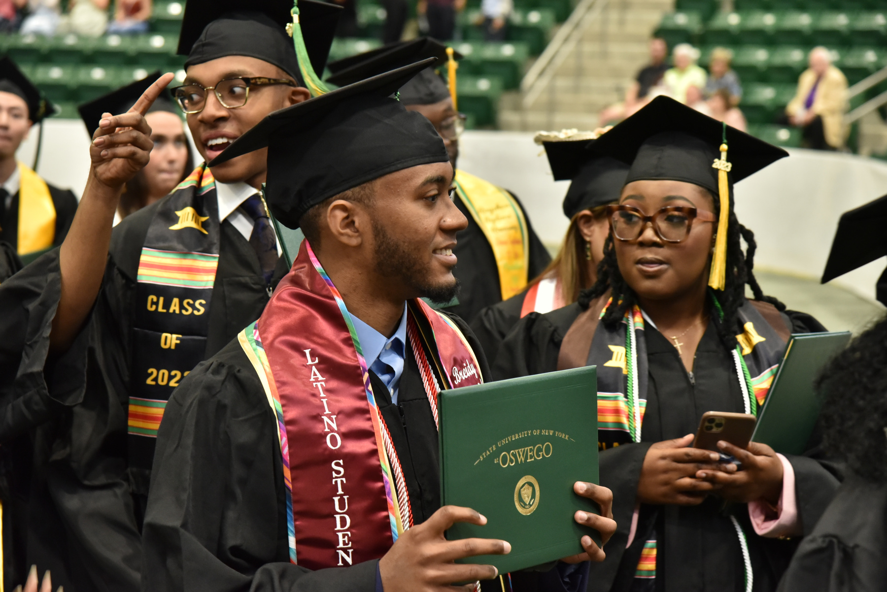 Breidy Siminiel, active in the Latino Student Union, and fellow grads exit their Commencement ceremony for the School of Business held in the Deborah F. Stanley Arena and Convocation Hall.